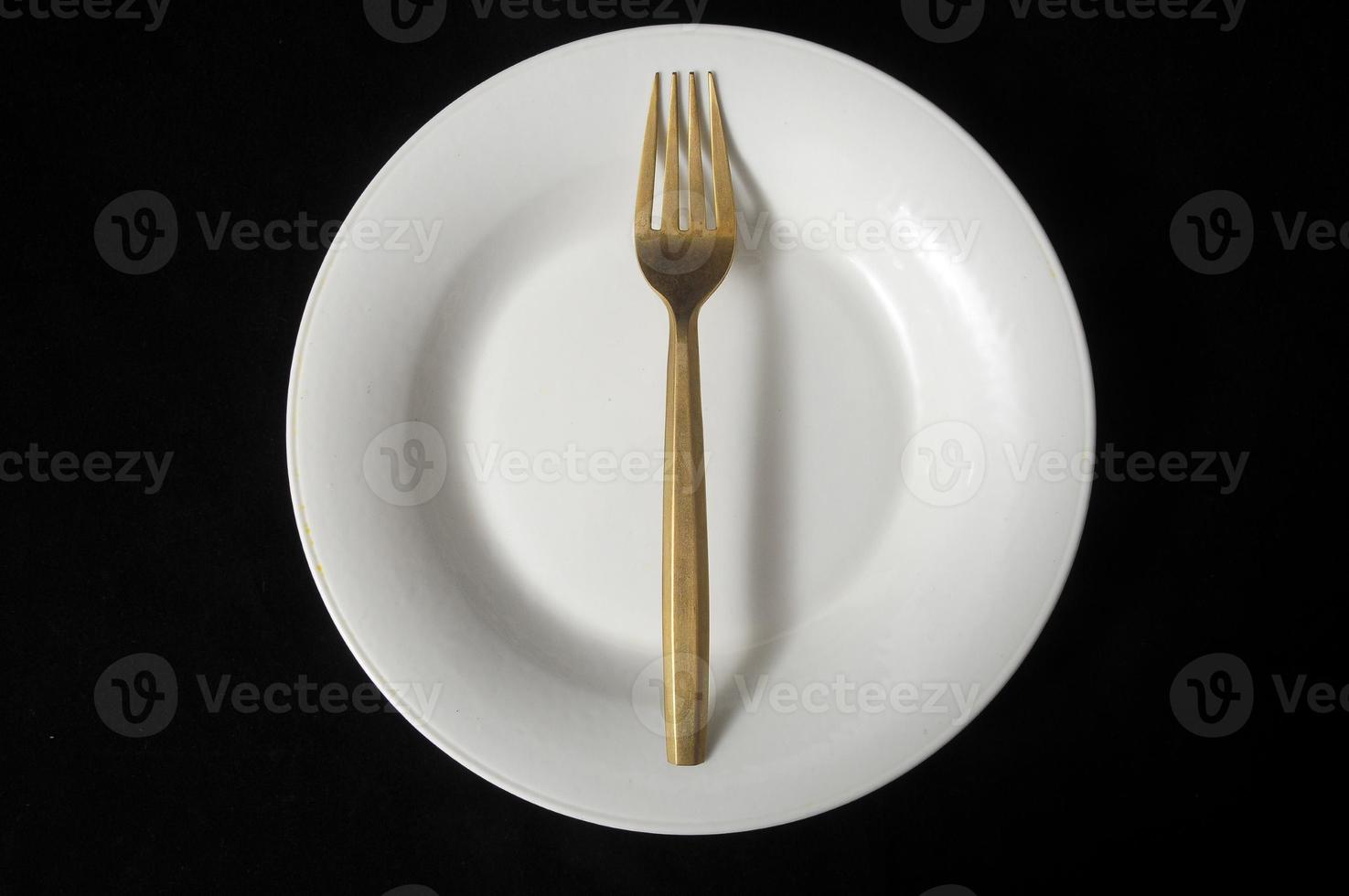 Metal fork and plate on black background photo