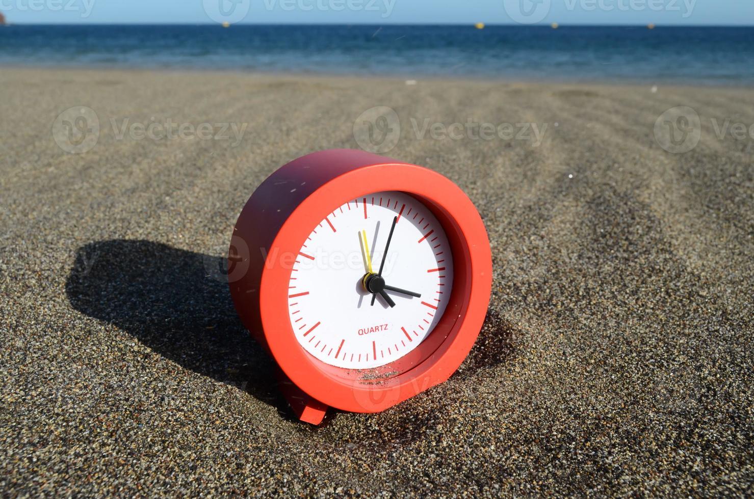Clock on the sand photo