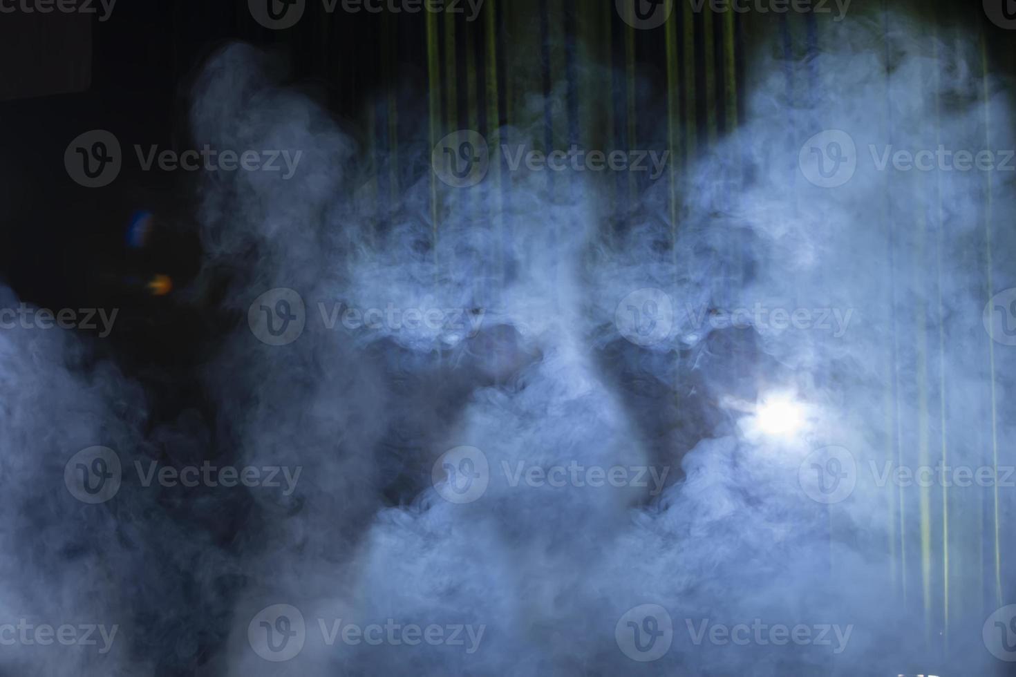 Green theatrical background with beam of light and blue smoke. photo