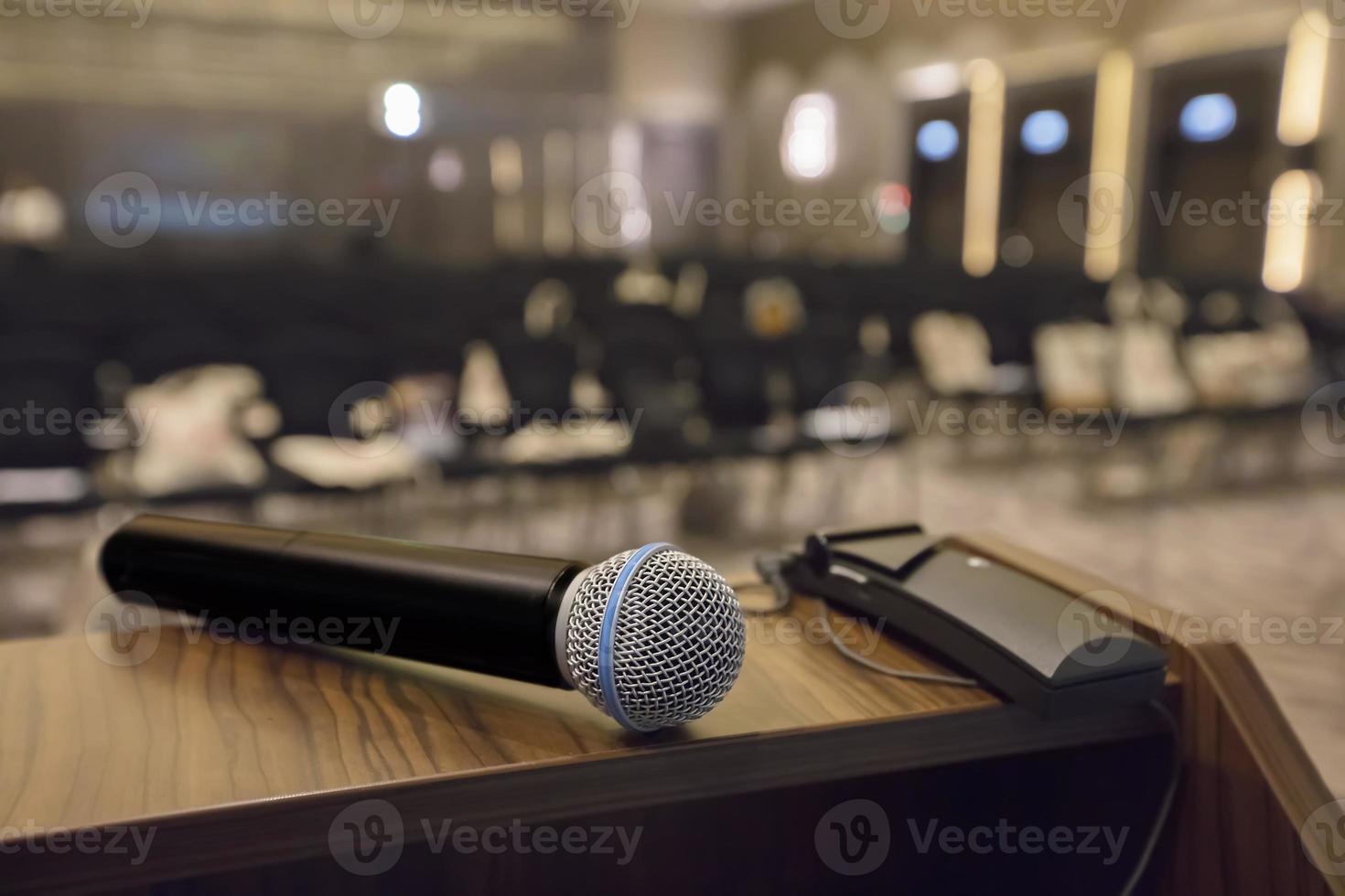 There is a microphone on the table against the background of an empty hall. photo