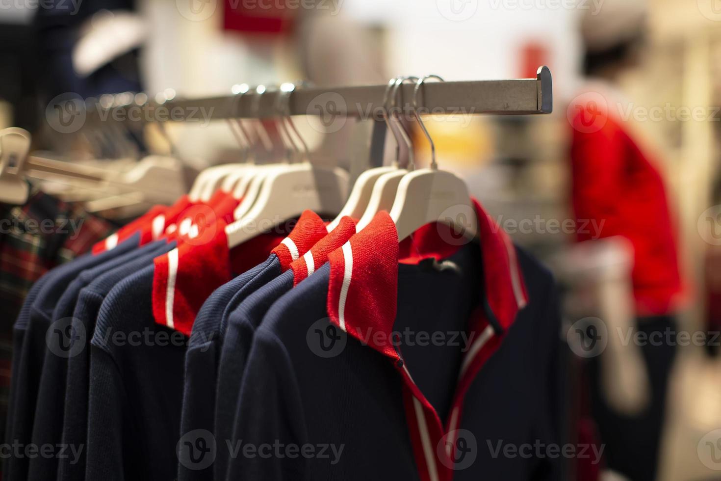 hay camisetas idénticas a la venta en una percha de una tienda. foto