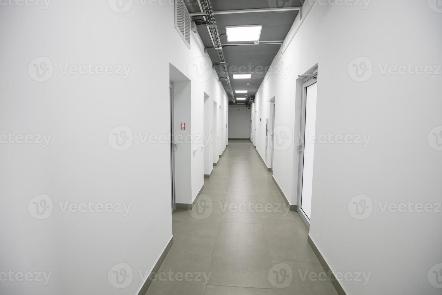 Empty white corridor with closed doors in an office building. photo