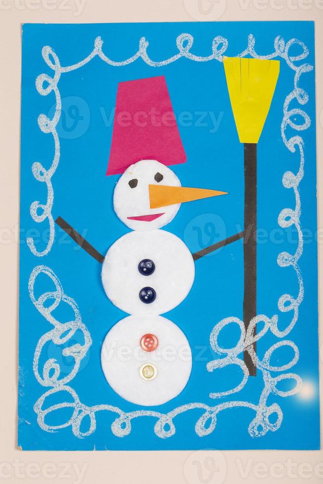manualidades de papel navideñas para niños. aplicación de la creatividad infantil. jardín de infantes y escuela de manualidades. sobre un fondo beige, un muñeco de nieve hecho de papel de colores. foto