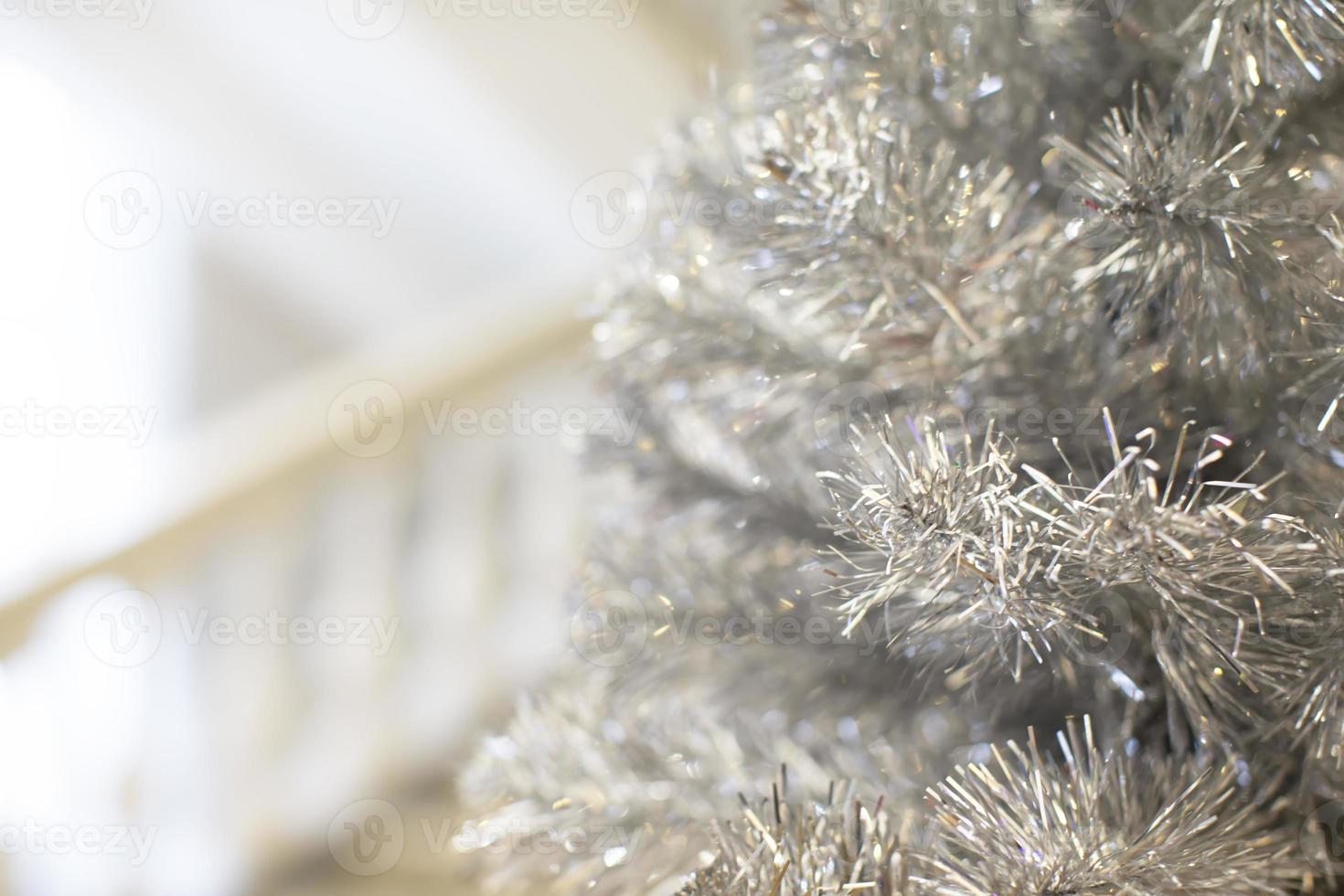 Part of a Christmas tree made of silver tinsel. White Christmas tree with silver decoration close-up. photo