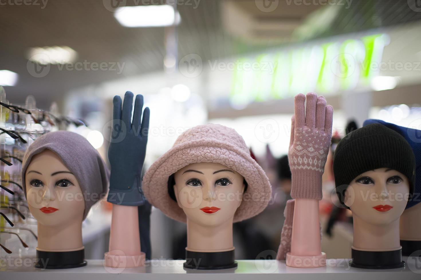 en la tienda hay cabezas de maniquíes con gorros tejidos y manos enguantadas. departamento para la venta de sombreros. foto