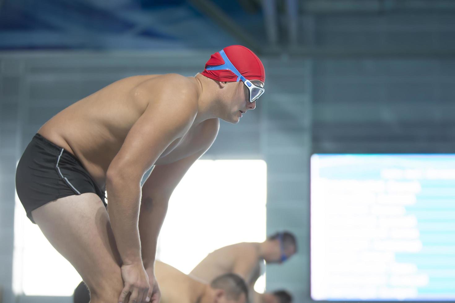 Belarus, city of Gomel, September 03, 2021. City sports pool.A male swimmer in a swimming cap and goggles on the background of the pool. photo