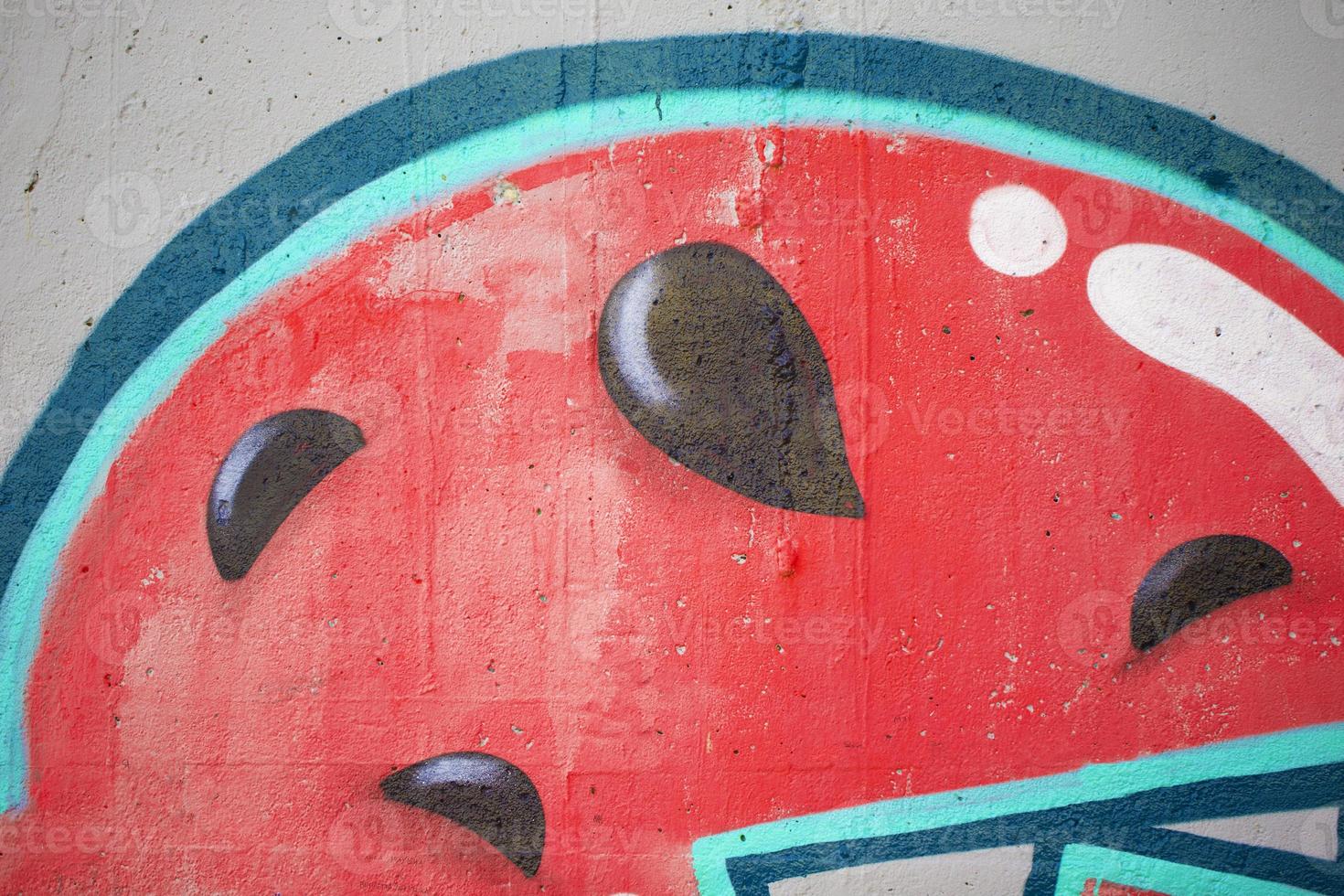Fragments of a watermelon painted on the wall. The wall is painted with spray paint. Concrete graffiti wall texture. photo