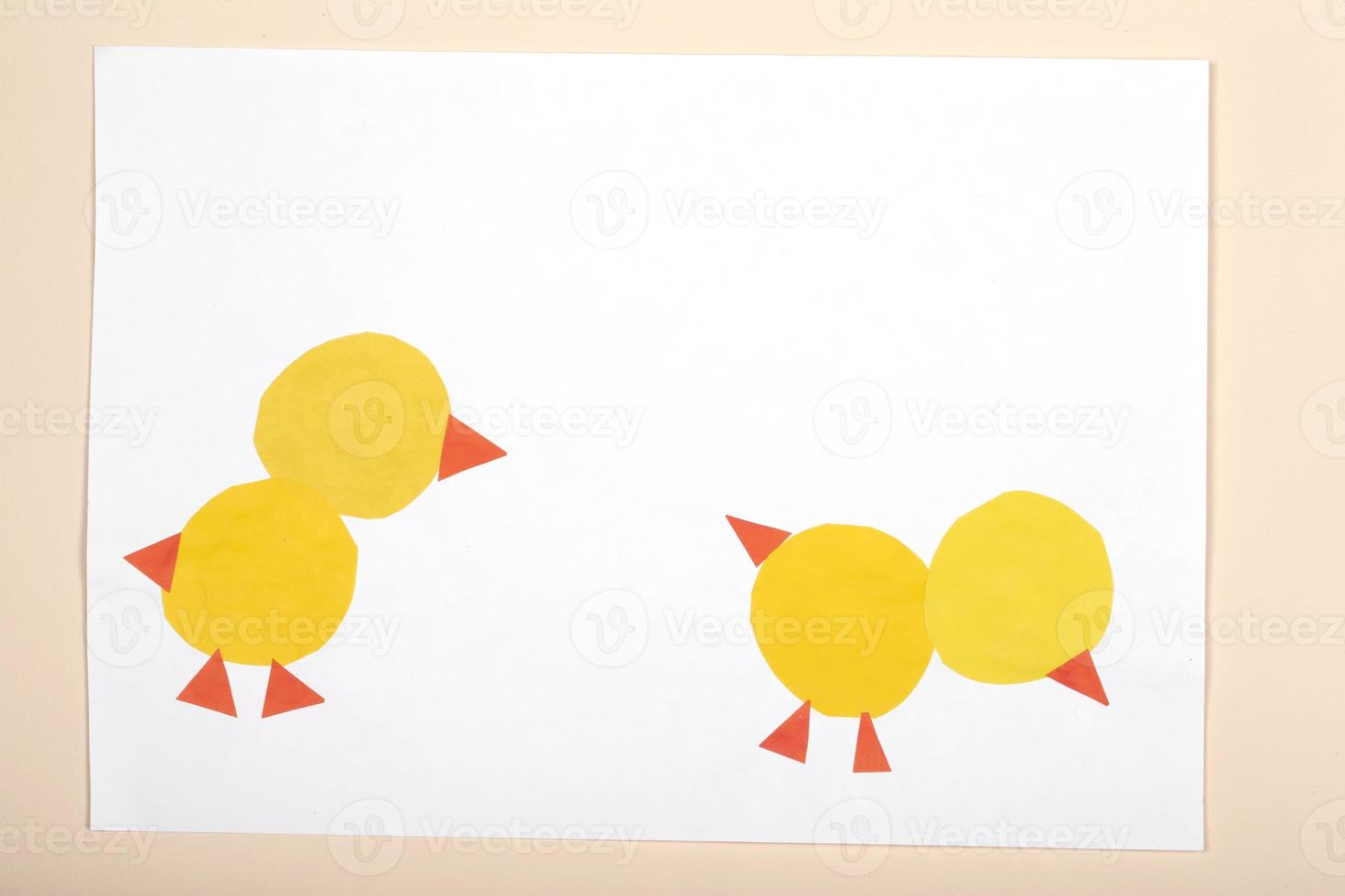Paper crafts for children. Application of children's creativity. Kindergarten and craft school. On a beige background made of colored paper chickens. photo