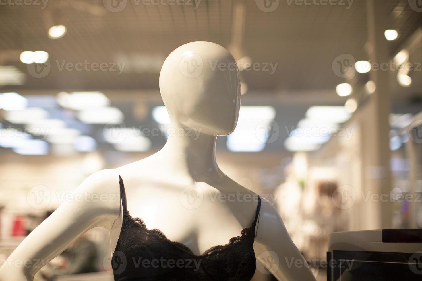 Mannequin of a woman in a bra in a shop window. photo