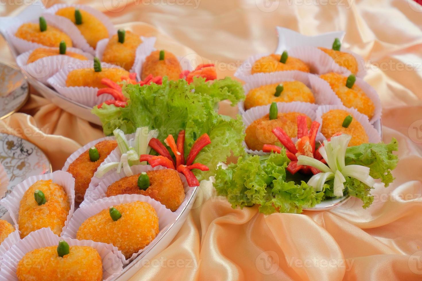 Kroket kentang is a traditional snack from Indonesia. served in wooden plate with green chilli. Delicious Indonesian Traditional Kroket Kentang with chilli photo