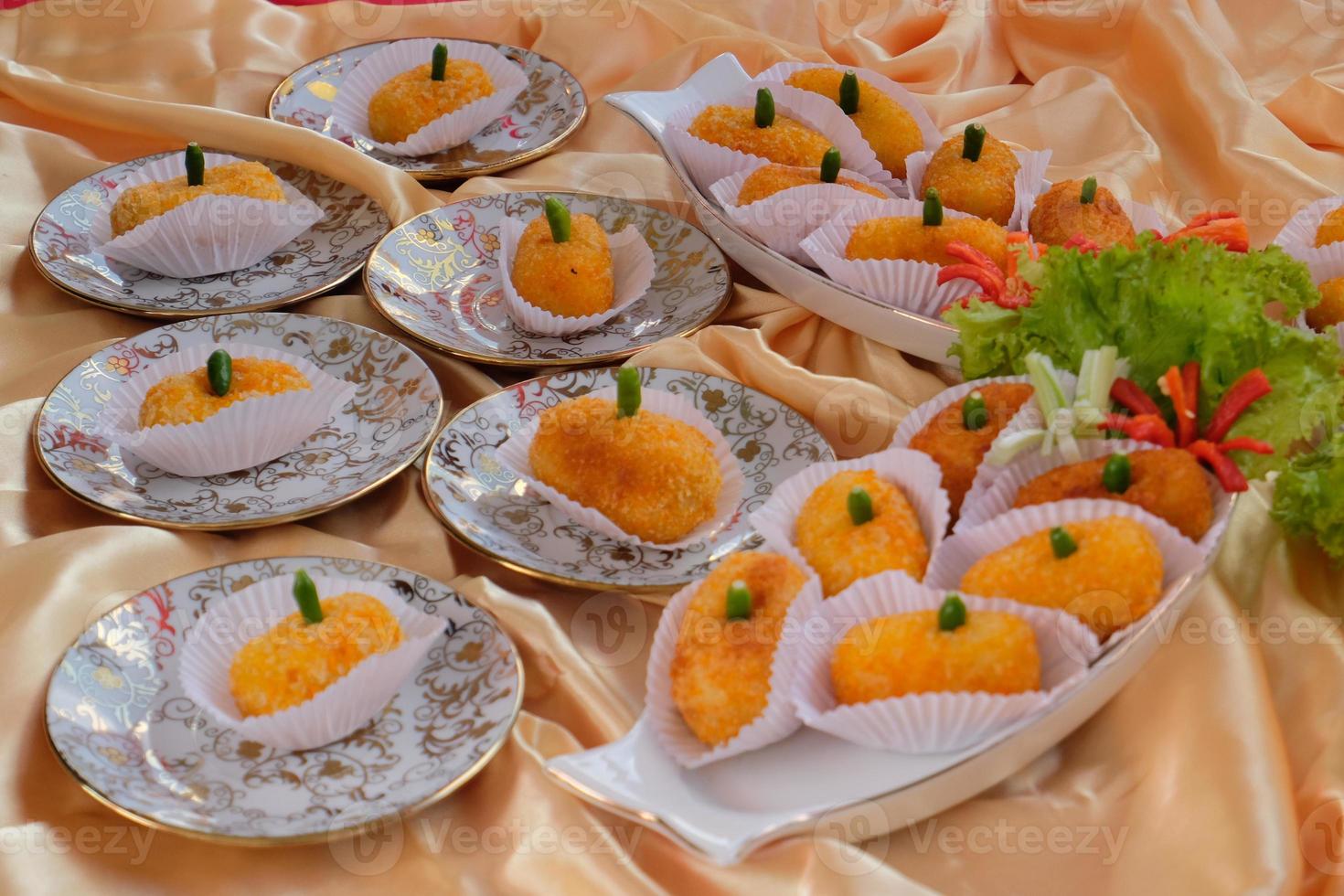 Kroket kentang is a traditional snack from Indonesia. served in wooden plate with green chilli. Delicious Indonesian Traditional Kroket Kentang with chilli photo