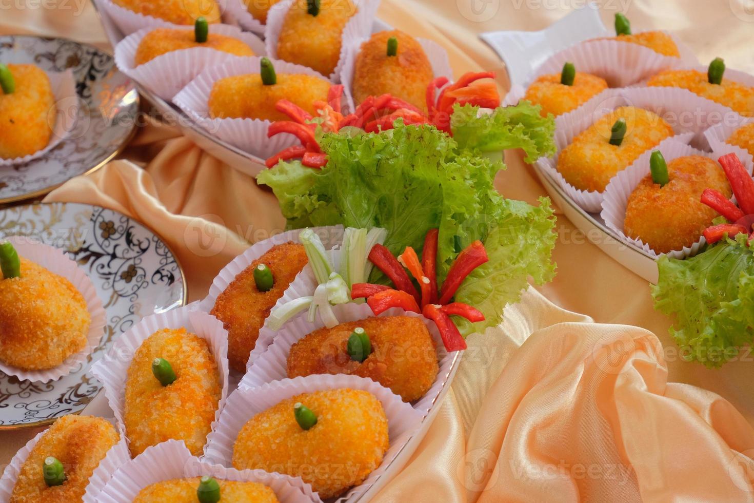 Kroket kentang is a traditional snack from Indonesia. served in wooden plate with green chilli. Delicious Indonesian Traditional Kroket Kentang with chilli photo