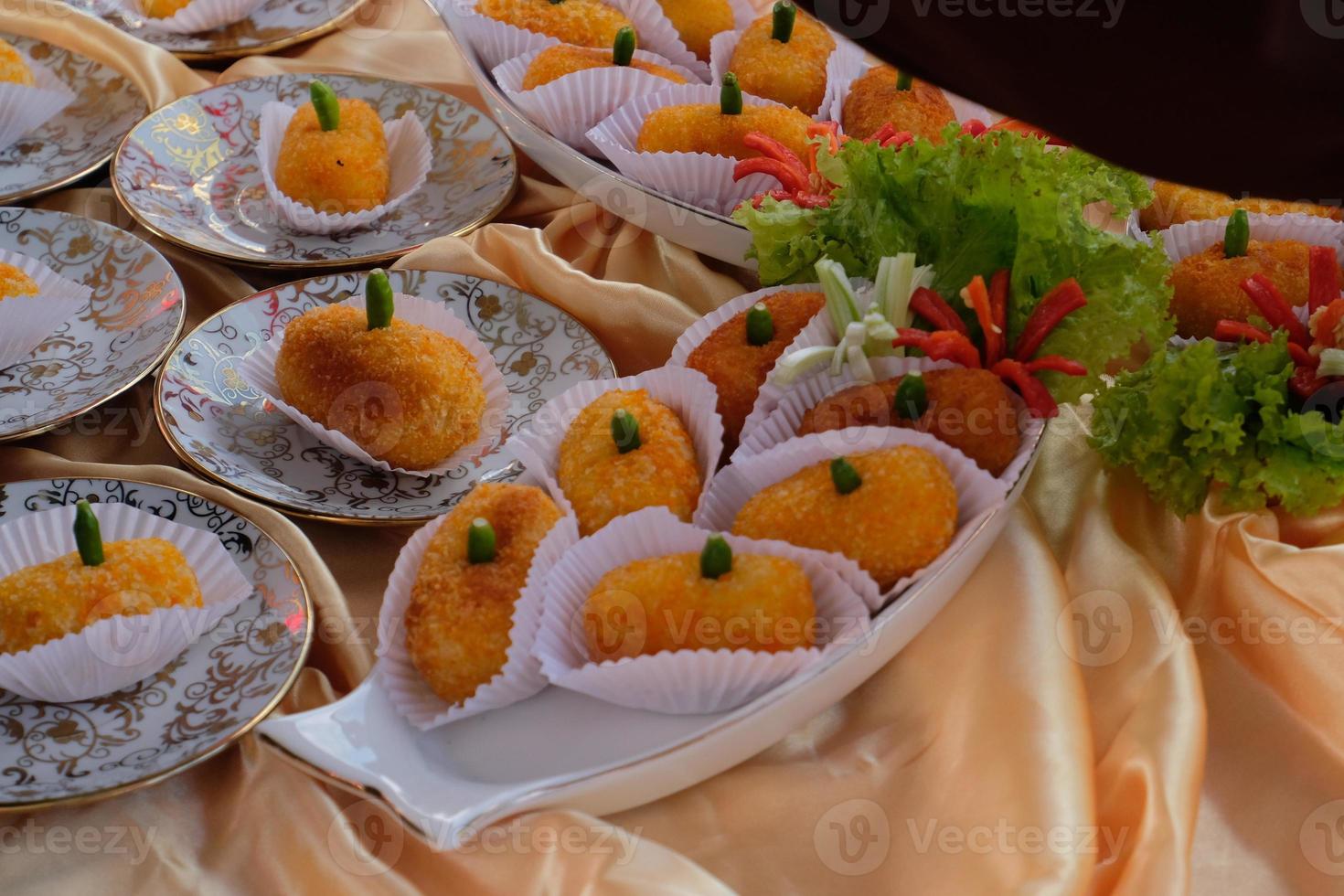 Kroket kentang is a traditional snack from Indonesia. served in wooden plate with green chilli. Delicious Indonesian Traditional Kroket Kentang with chilli photo