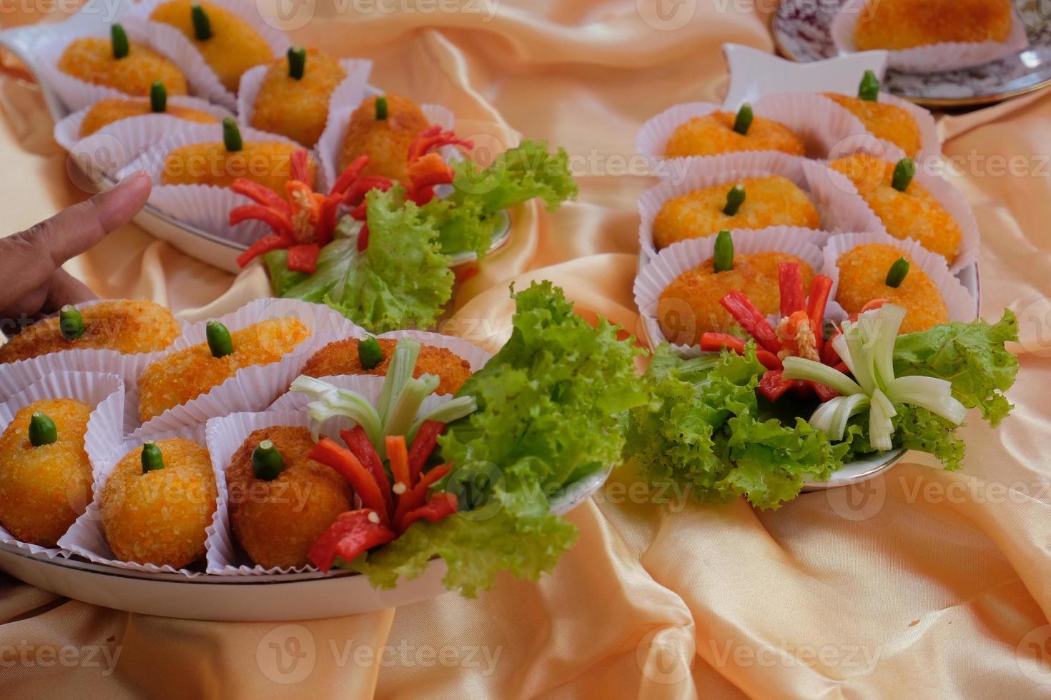 Kroket kentang is a traditional snack from Indonesia. served in wooden plate with green chilli. Delicious Indonesian Traditional Kroket Kentang with chilli photo