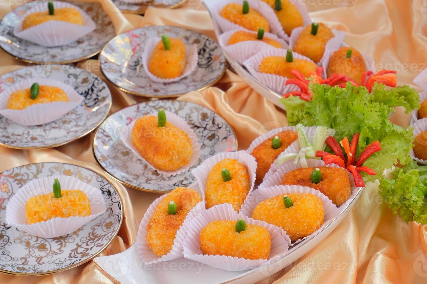 Kroket kentang is a traditional snack from Indonesia. served in wooden plate with green chilli. Delicious Indonesian Traditional Kroket Kentang with chilli photo