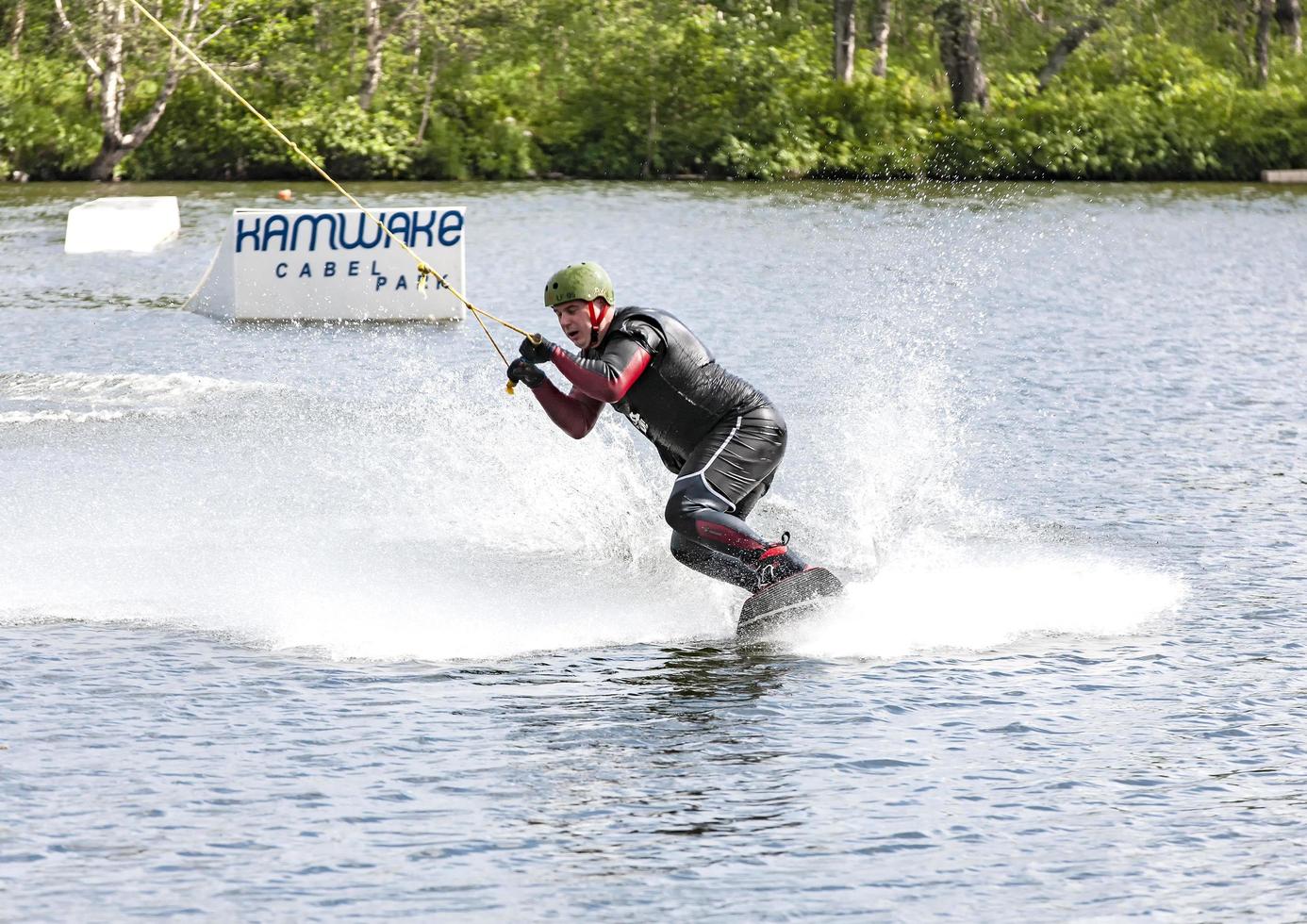 Kamchatka, Russia- 10 June 2021 -  Man wakeboarding on lake in Kamchatka behind boat photo