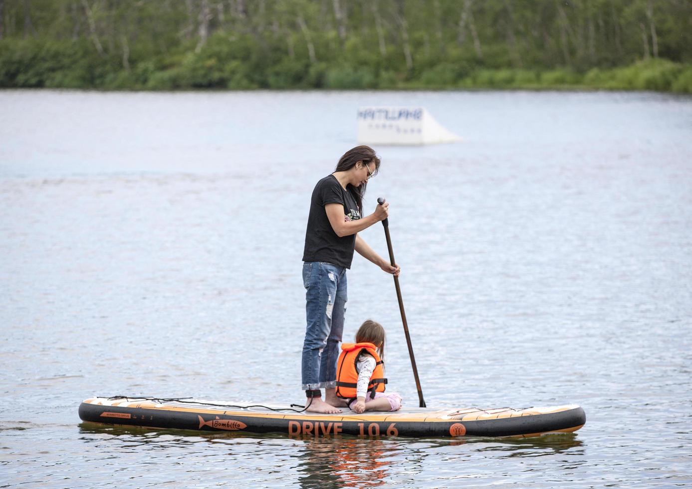 Kamchatka, Russia- 10 June 2021 -  Men and women with her baby stand up paddle boarding photo