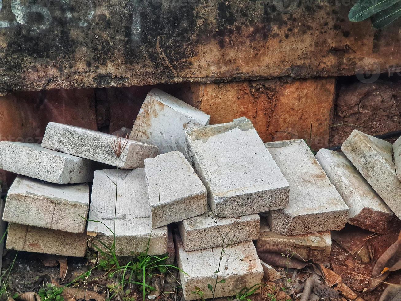 Piles of light bricks or conbloc scattered on the side of the road photo