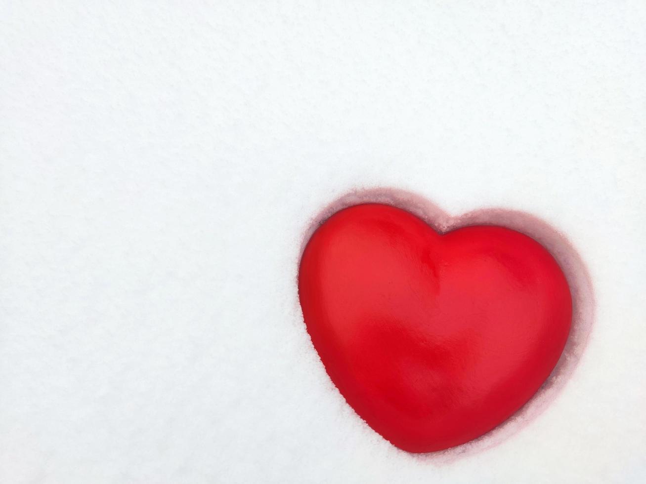 Red heart on snow photo