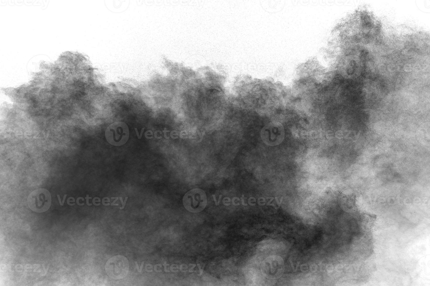 Black powder explosion against white background.Charcoal dust particles cloud. photo