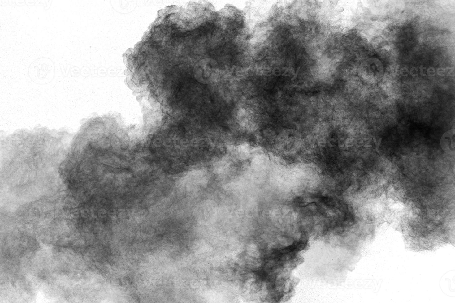 Black powder explosion against white background.Charcoal dust particles cloud. photo