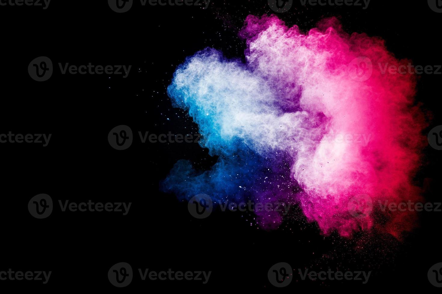 Freeze motion explosion of blue pink dust on  black background. Stopping the movement of colorful powder cloud. photo