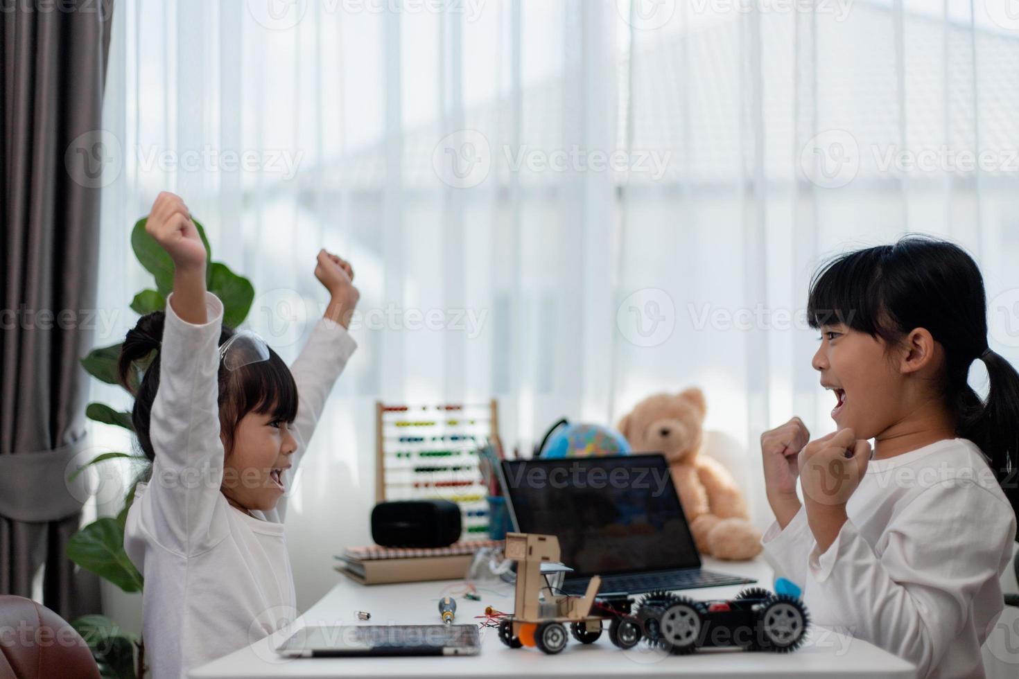 Asia students learn at home in coding robot cars and electronic board cables in STEM, STEAM, mathematics engineering science technology computer code in robotics for kids concept. photo