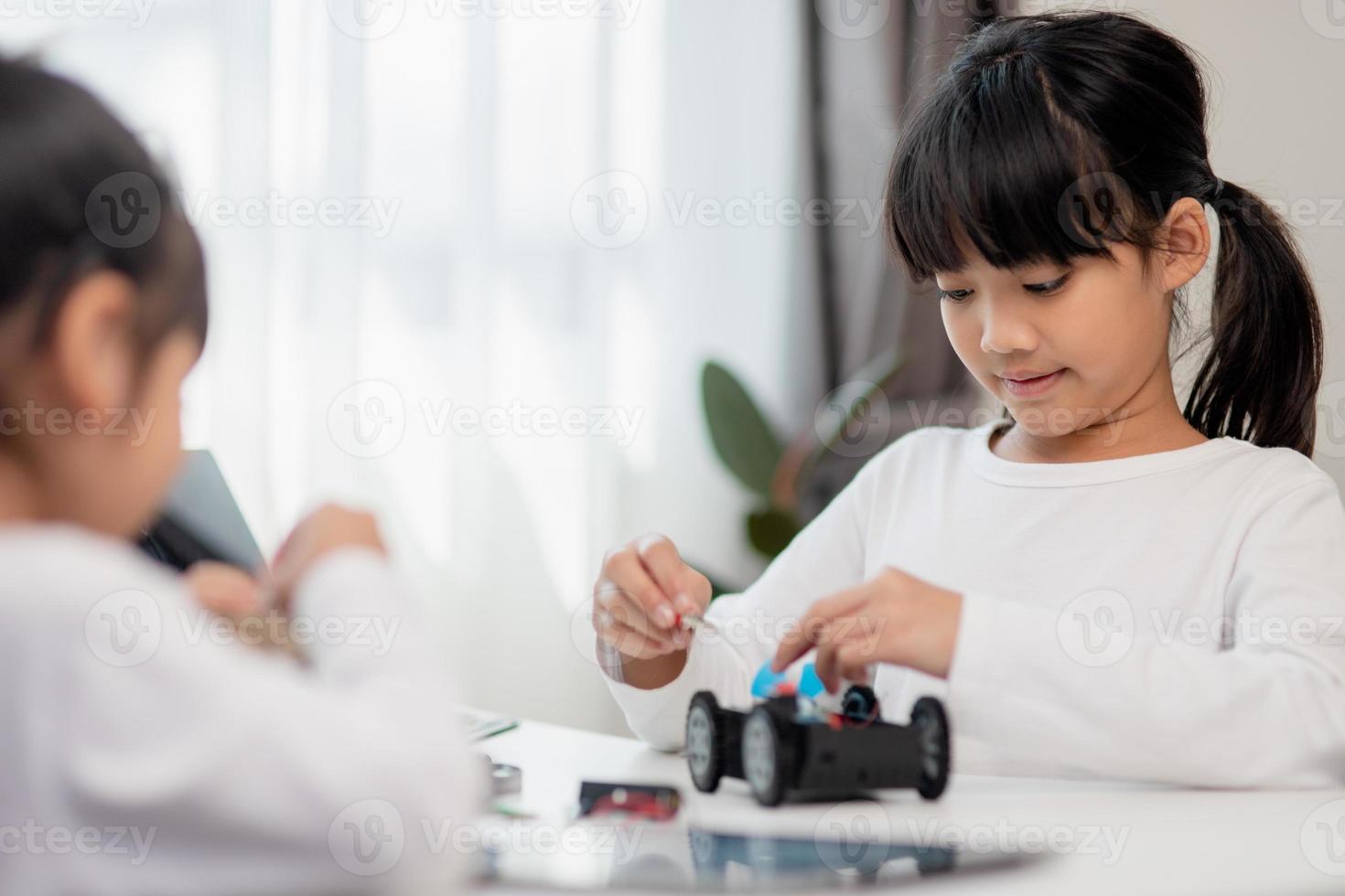 Asia students learn at home in coding robot cars and electronic board cables in STEM, STEAM, mathematics engineering science technology computer code in robotics for kids concept. photo