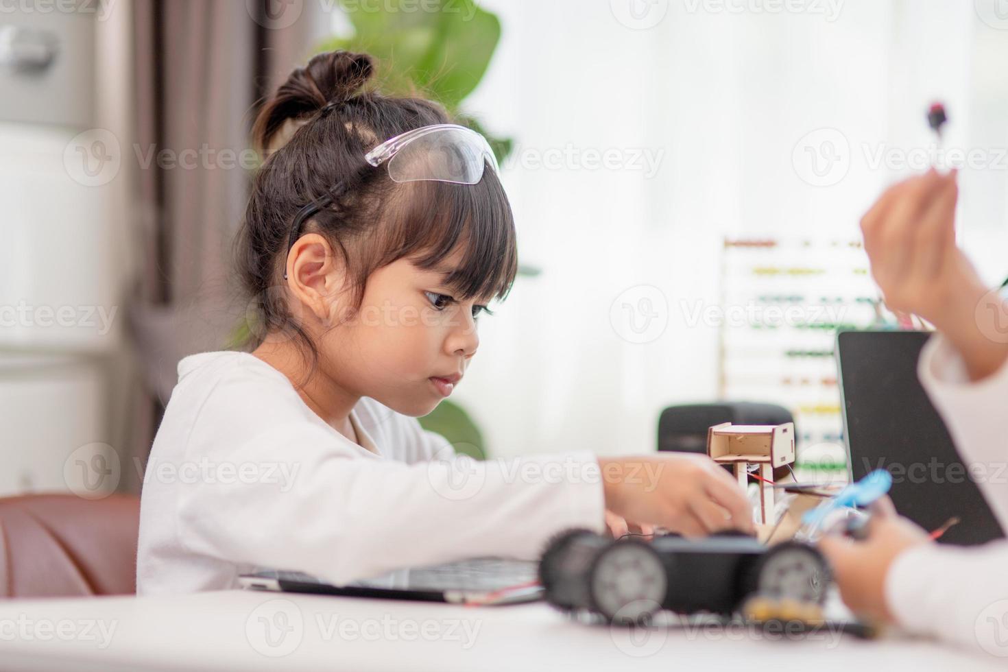 Asia students learn at home in coding robot cars and electronic board cables in STEM, STEAM, mathematics engineering science technology computer code in robotics for kids concept. photo