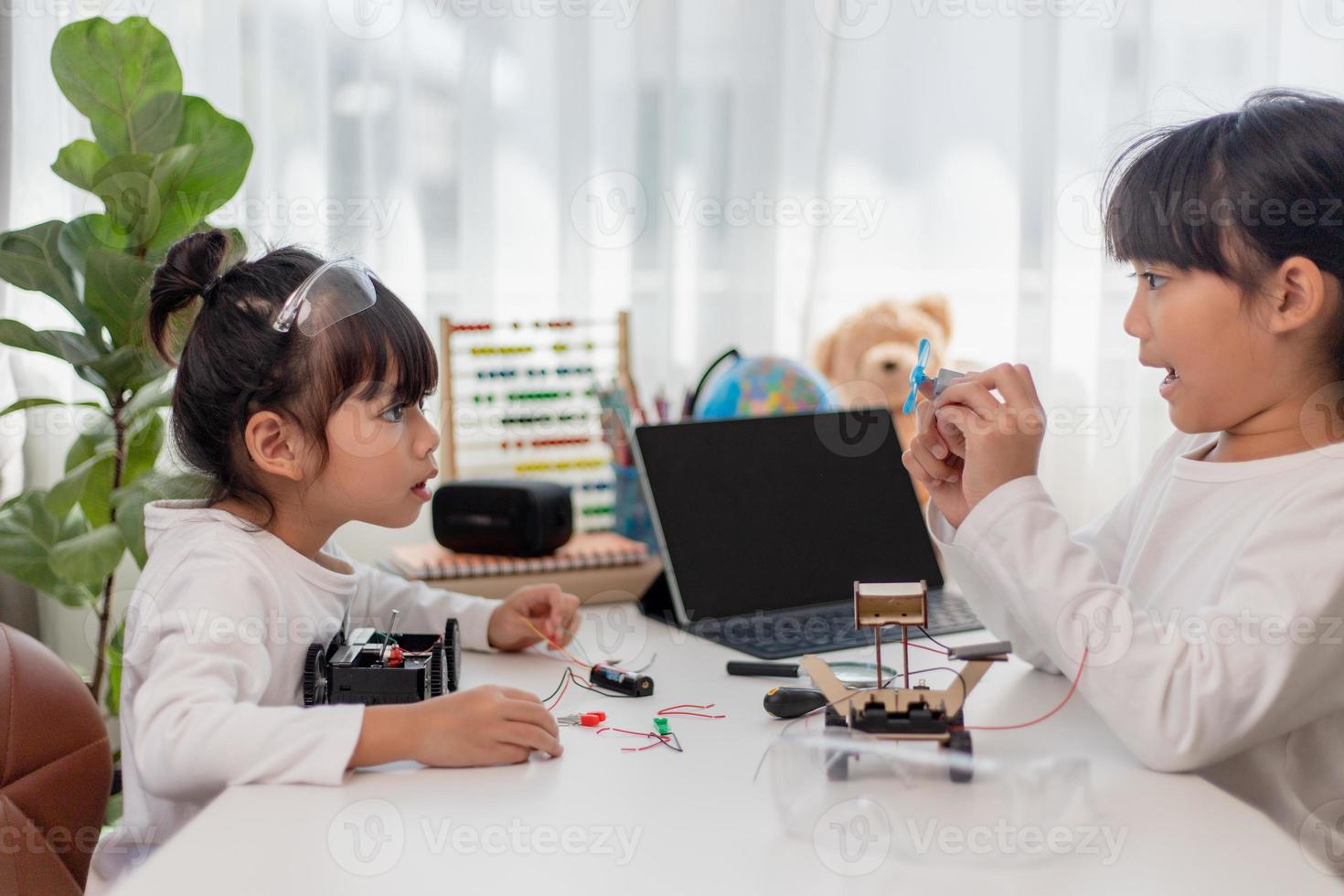 Asia students learn at home in coding robot cars and electronic board cables in STEM, STEAM, mathematics engineering science technology computer code in robotics for kids concept. photo