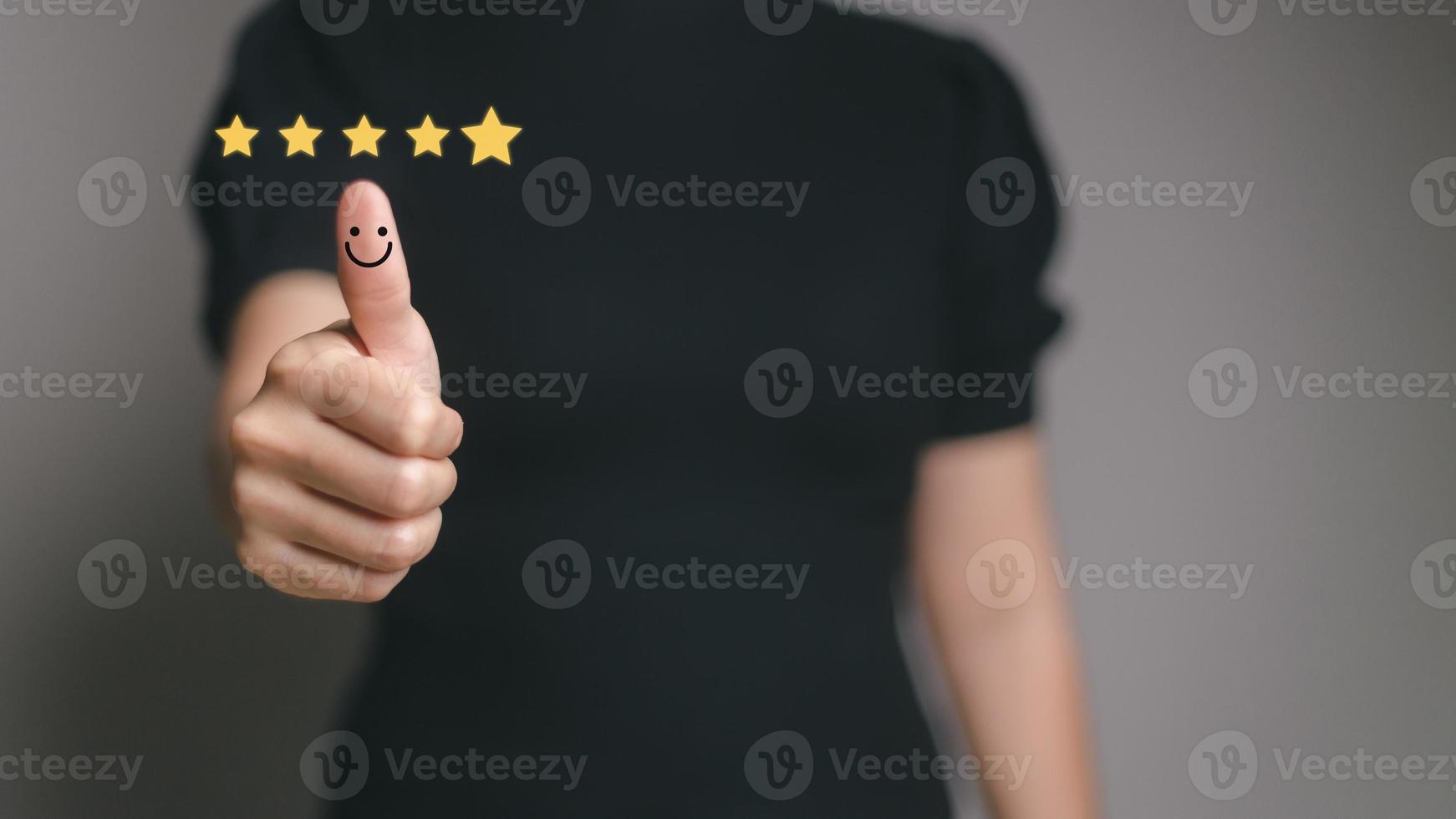 concepto de satisfacción del cliente. mano con pulgar arriba icono de cara sonriente de emoción positiva y cinco estrellas con espacio de copia. foto