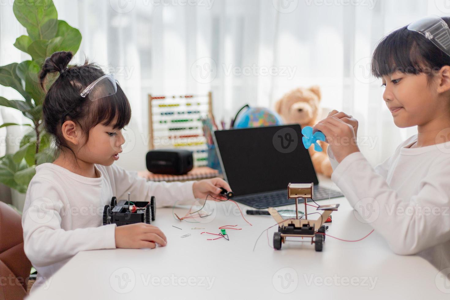 Asia students learn at home in coding robot cars and electronic board cables in STEM, STEAM, mathematics engineering science technology computer code in robotics for kids concept. photo