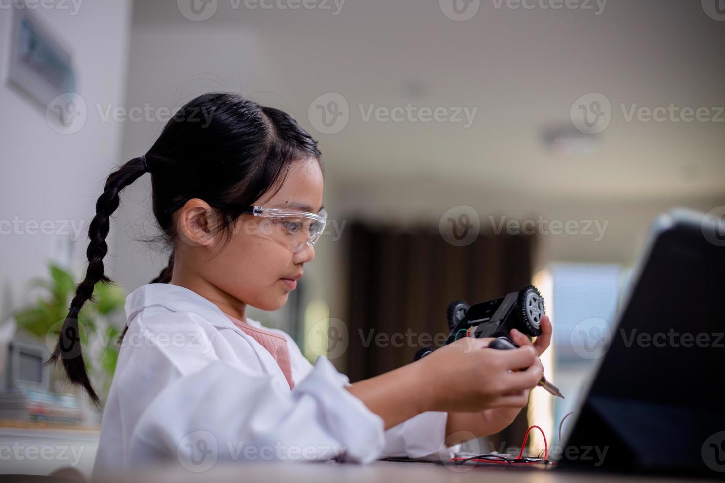 Asian students learn at home by coding robot cars and electronic board cables in STEM, STEAM, mathematics engineering science technology computer code in robotics for kids' concepts. photo