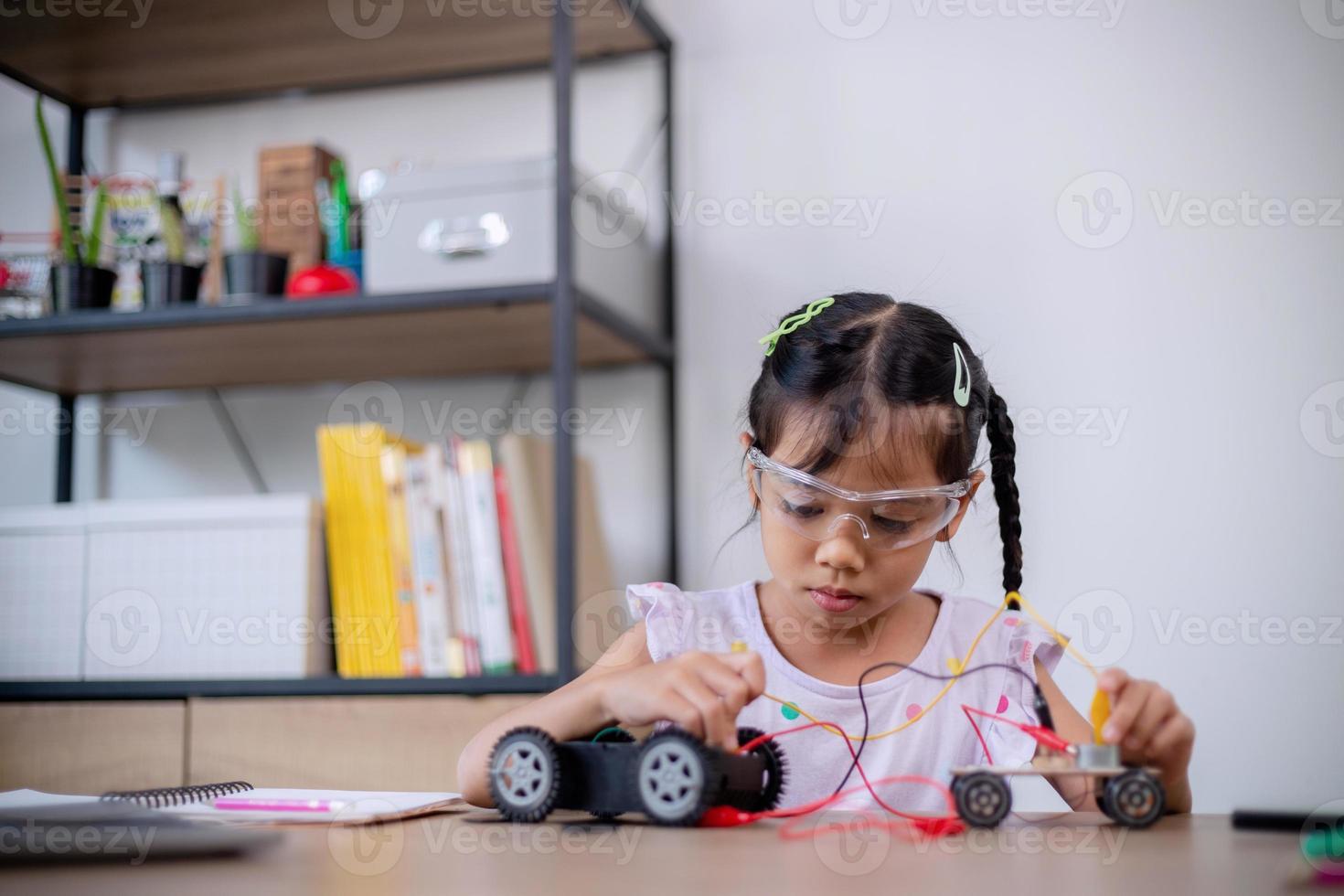 Asian students learn at home by coding robot cars and electronic board cables in STEM, STEAM, mathematics engineering science technology computer code in robotics for kids' concepts. photo