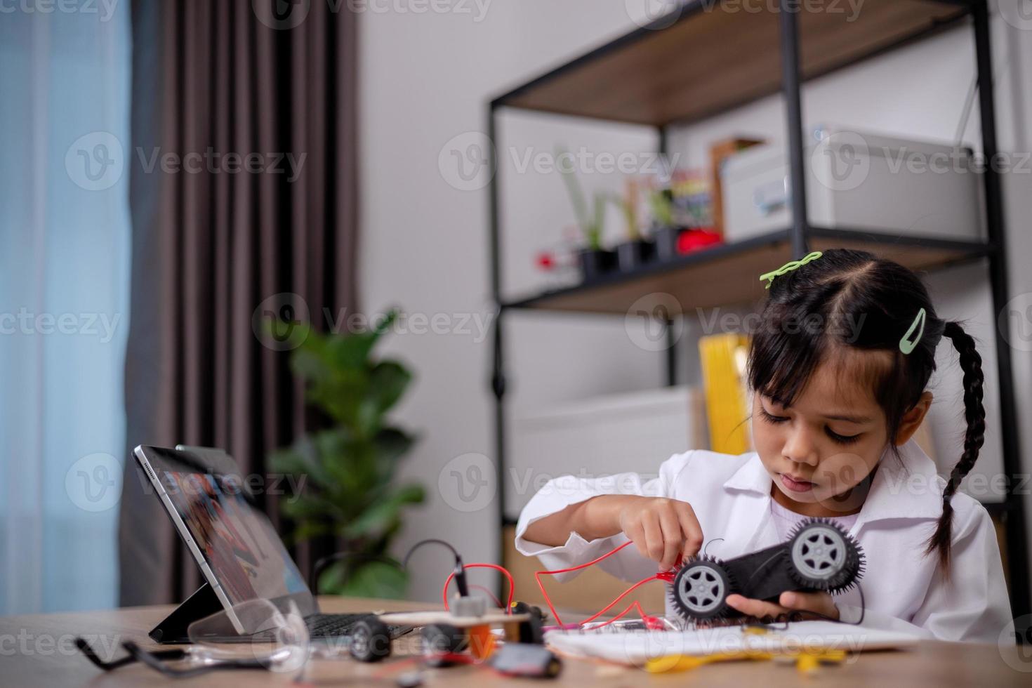 Asian students learn at home by coding robot cars and electronic board cables in STEM, STEAM, mathematics engineering science technology computer code in robotics for kids' concepts. photo