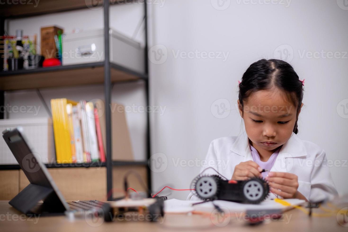 Asian students learn at home by coding robot cars and electronic board cables in STEM, STEAM, mathematics engineering science technology computer code in robotics for kids' concepts. photo