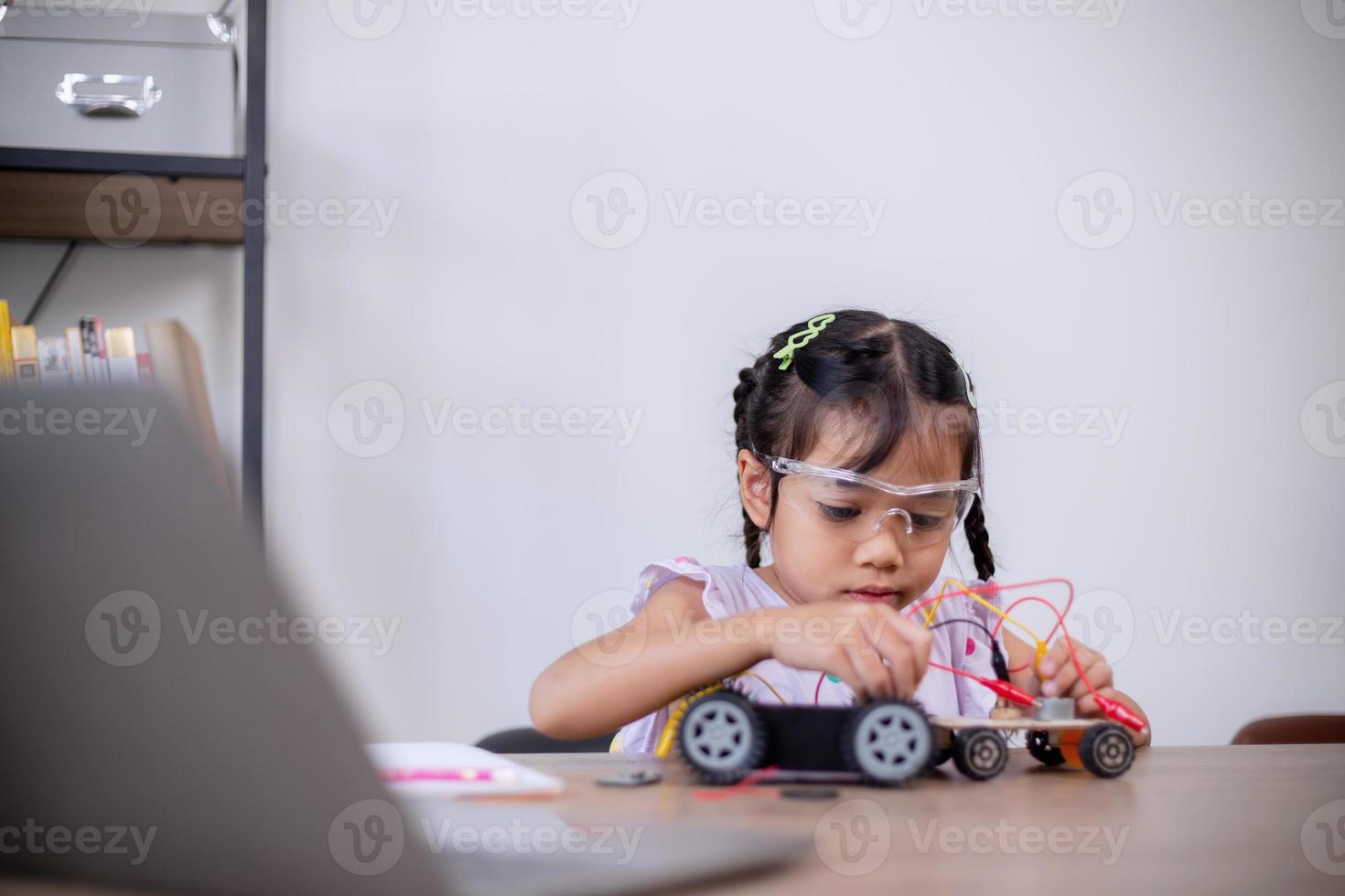 Asian students learn at home by coding robot cars and electronic board cables in STEM, STEAM, mathematics engineering science technology computer code in robotics for kids' concepts. photo