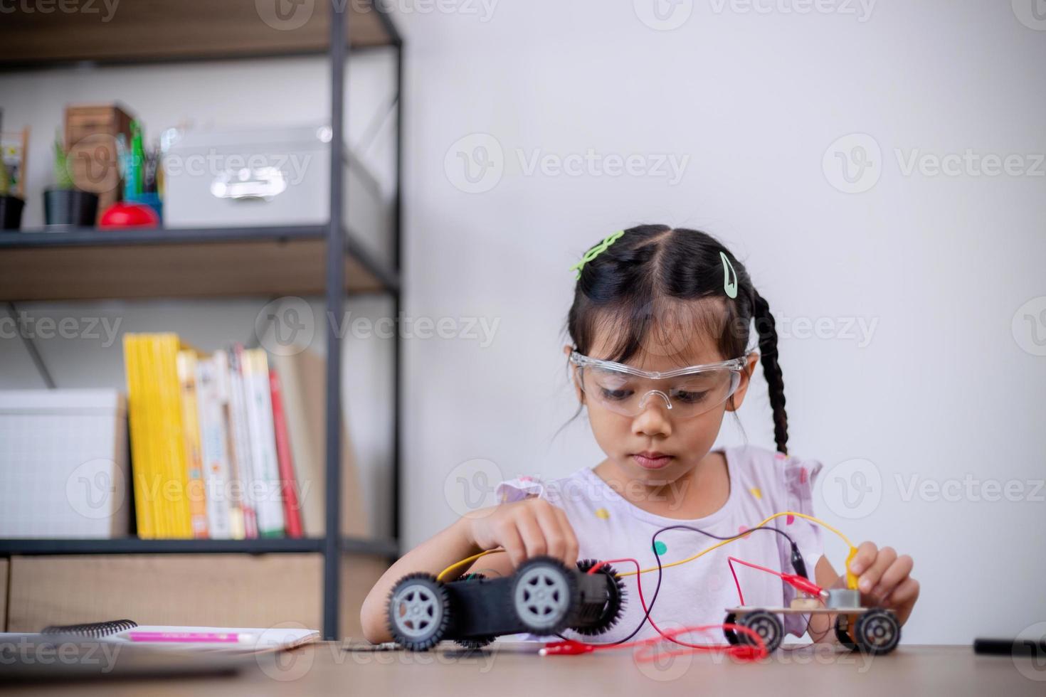 Asian students learn at home by coding robot cars and electronic board cables in STEM, STEAM, mathematics engineering science technology computer code in robotics for kids' concepts. photo