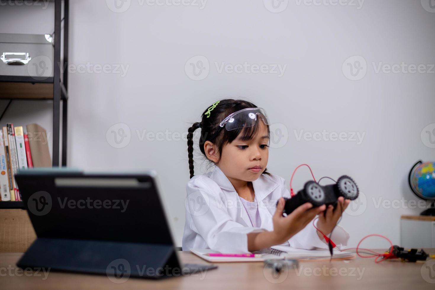 los estudiantes asiáticos aprenden en casa codificando automóviles robot y cables de placas electrónicas en tallo, vapor, ingeniería matemática, ciencia, tecnología, código informático en robótica para conceptos infantiles. foto