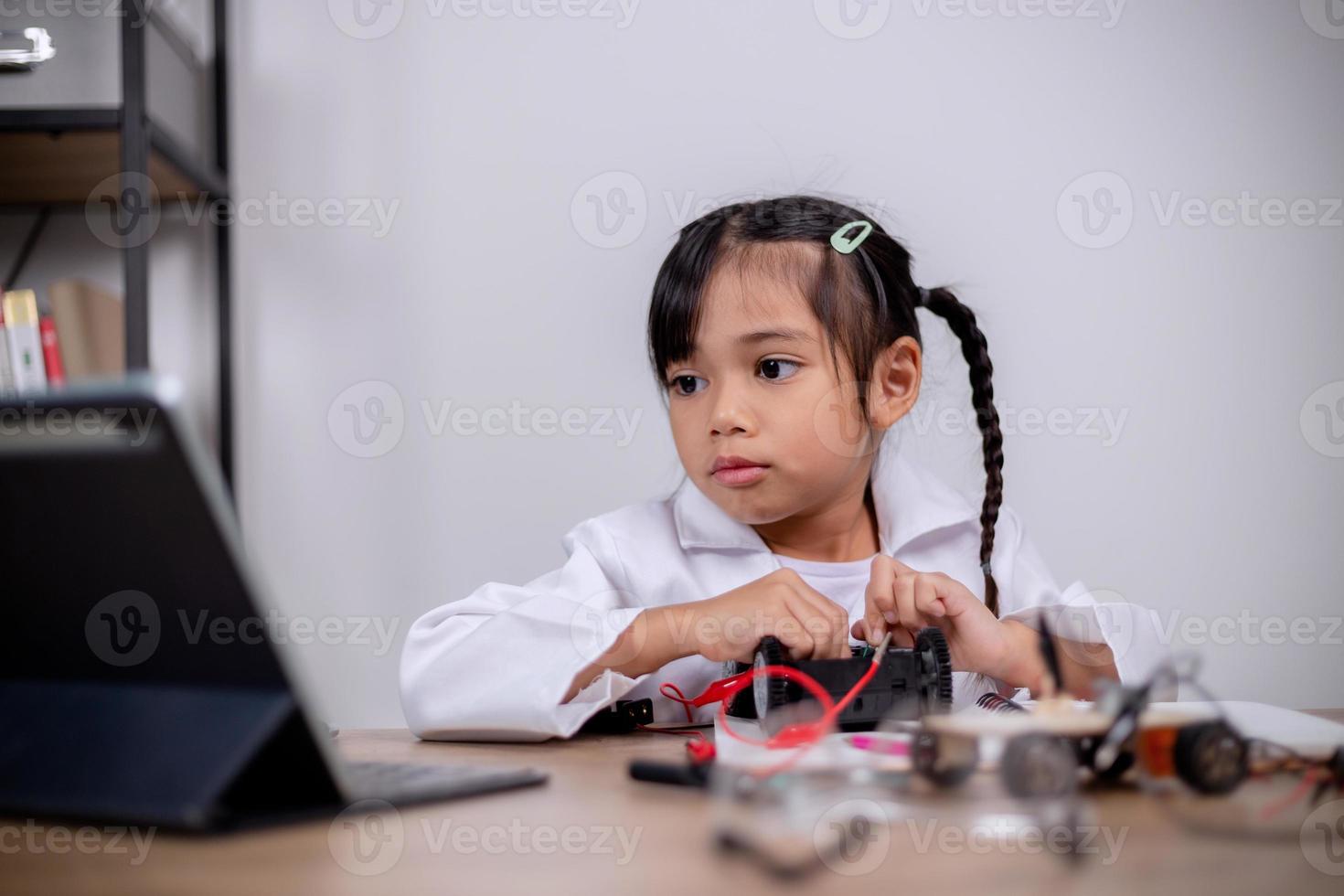 los estudiantes asiáticos aprenden en casa codificando automóviles robot y cables de placas electrónicas en tallo, vapor, ingeniería matemática, ciencia, tecnología, código informático en robótica para conceptos infantiles. foto