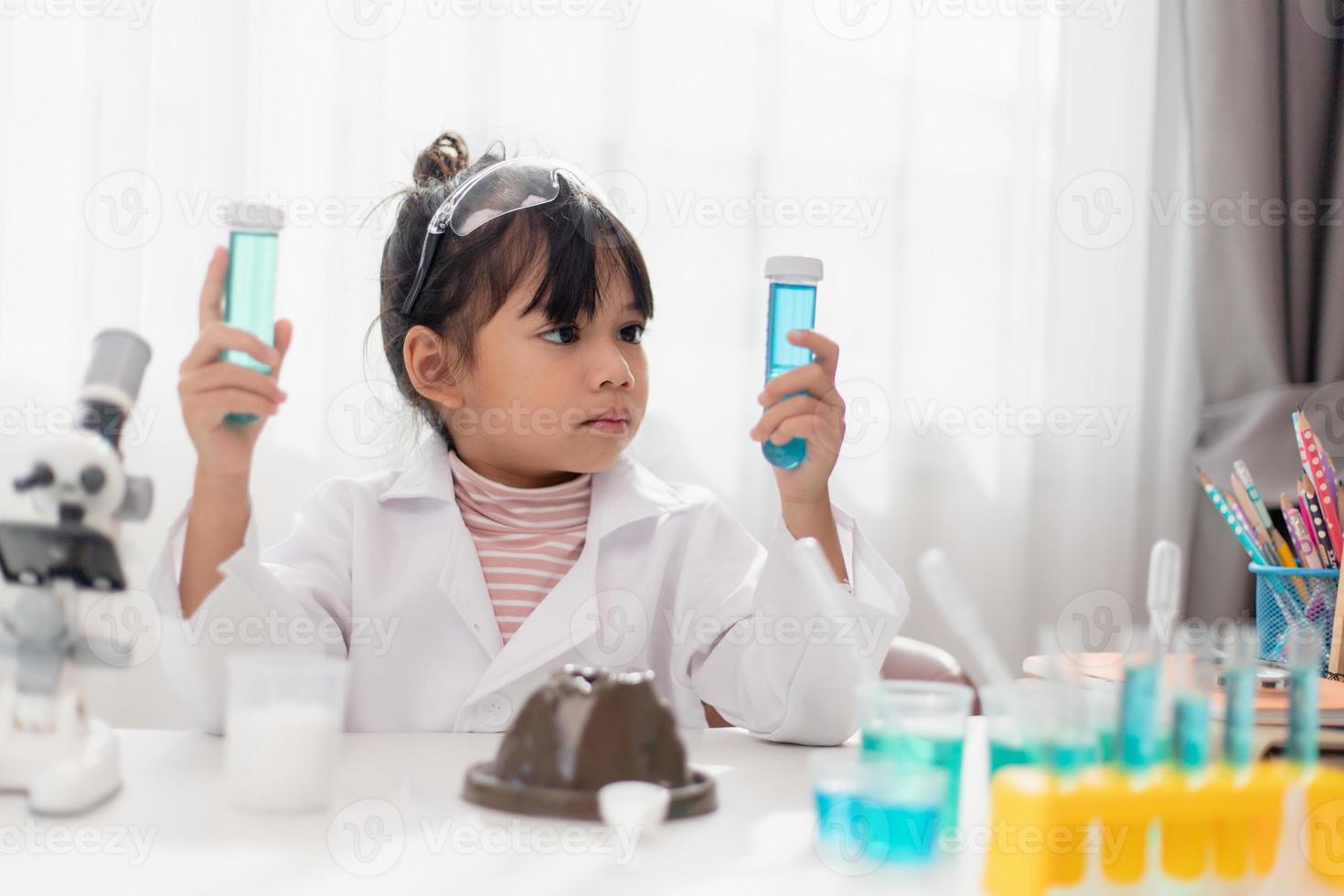 education, science, chemistry and children concept - kids or students with test tube making experiment at school laboratory photo