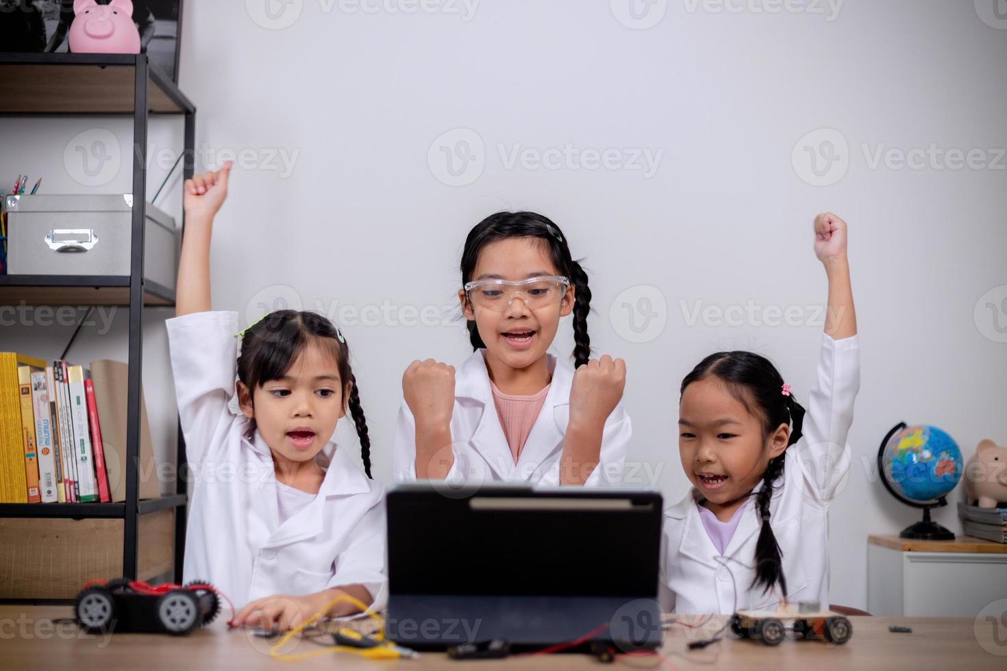 Asian students learn at home by coding robot cars and electronic board cables in STEM, STEAM, mathematics engineering science technology computer code in robotics for kids' concepts. photo