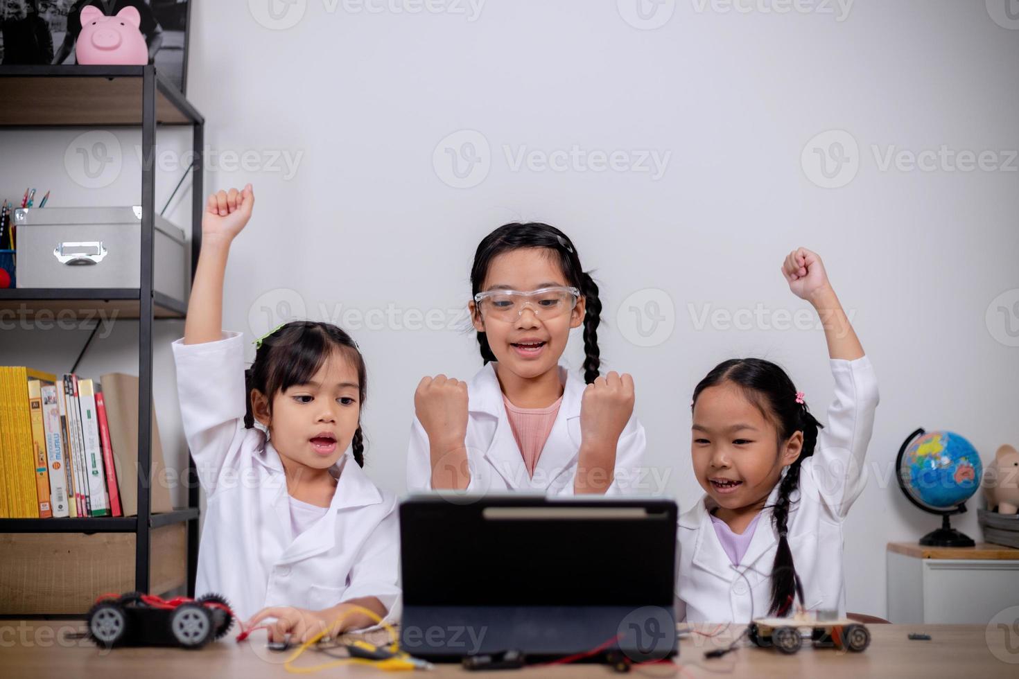 Asian students learn at home by coding robot cars and electronic board cables in STEM, STEAM, mathematics engineering science technology computer code in robotics for kids' concepts. photo