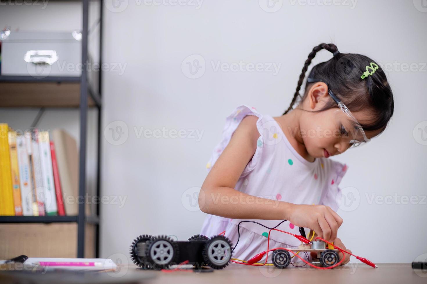 Asian students learn at home by coding robot cars and electronic board cables in STEM, STEAM, mathematics engineering science technology computer code in robotics for kids' concepts. photo