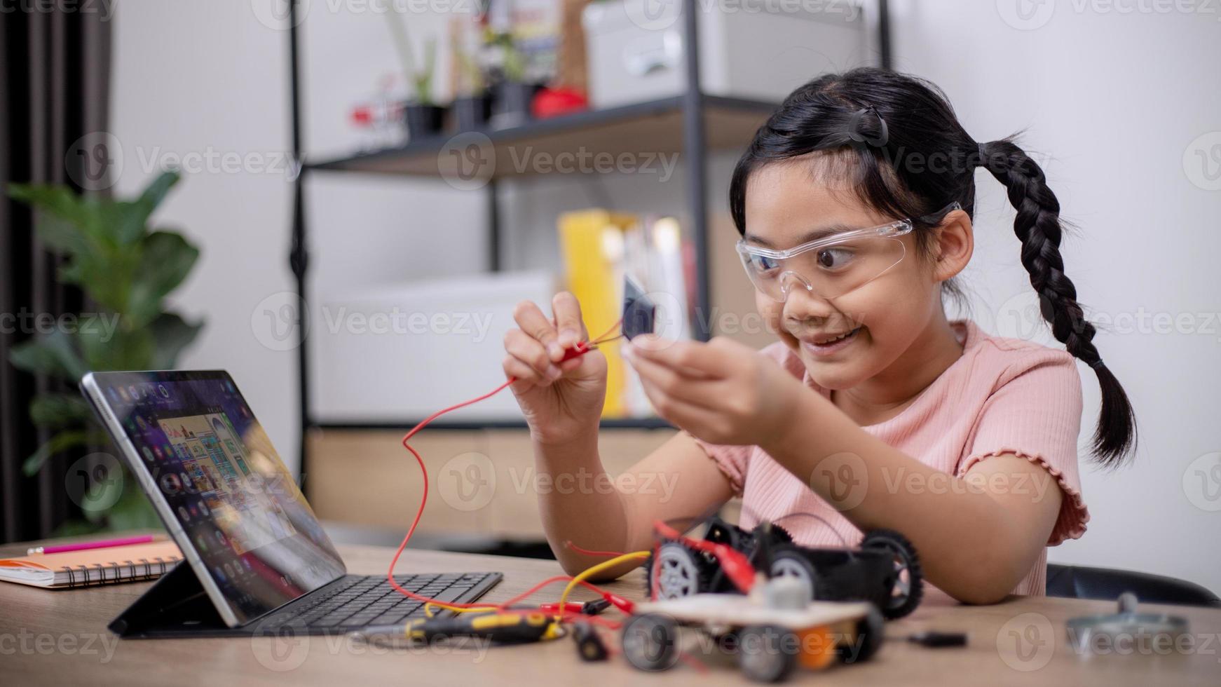 Asian students learn at home by coding robot cars and electronic board ...