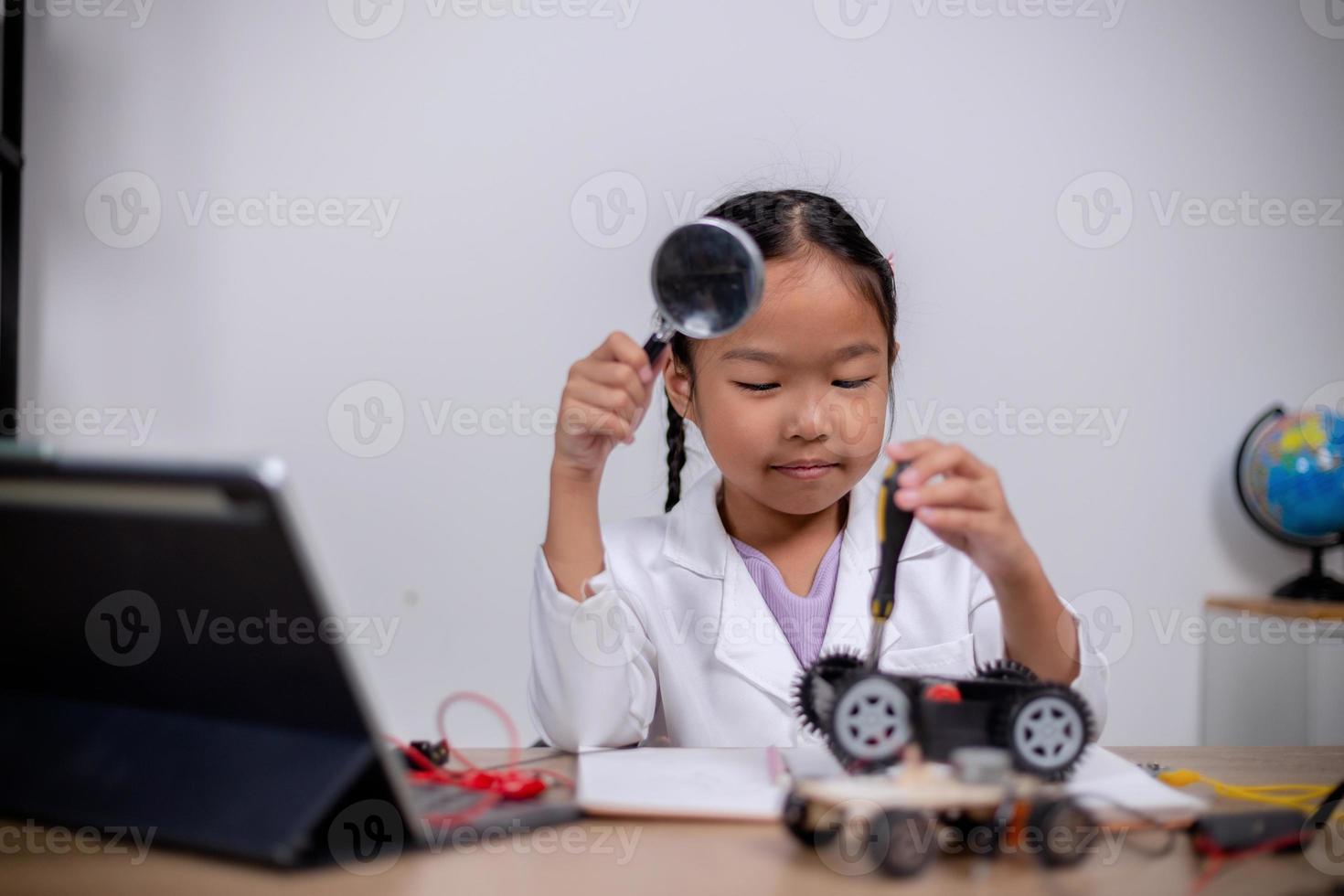 Asian students learn at home by coding robot cars and electronic board cables in STEM, STEAM, mathematics engineering science technology computer code in robotics for kids' concepts. photo