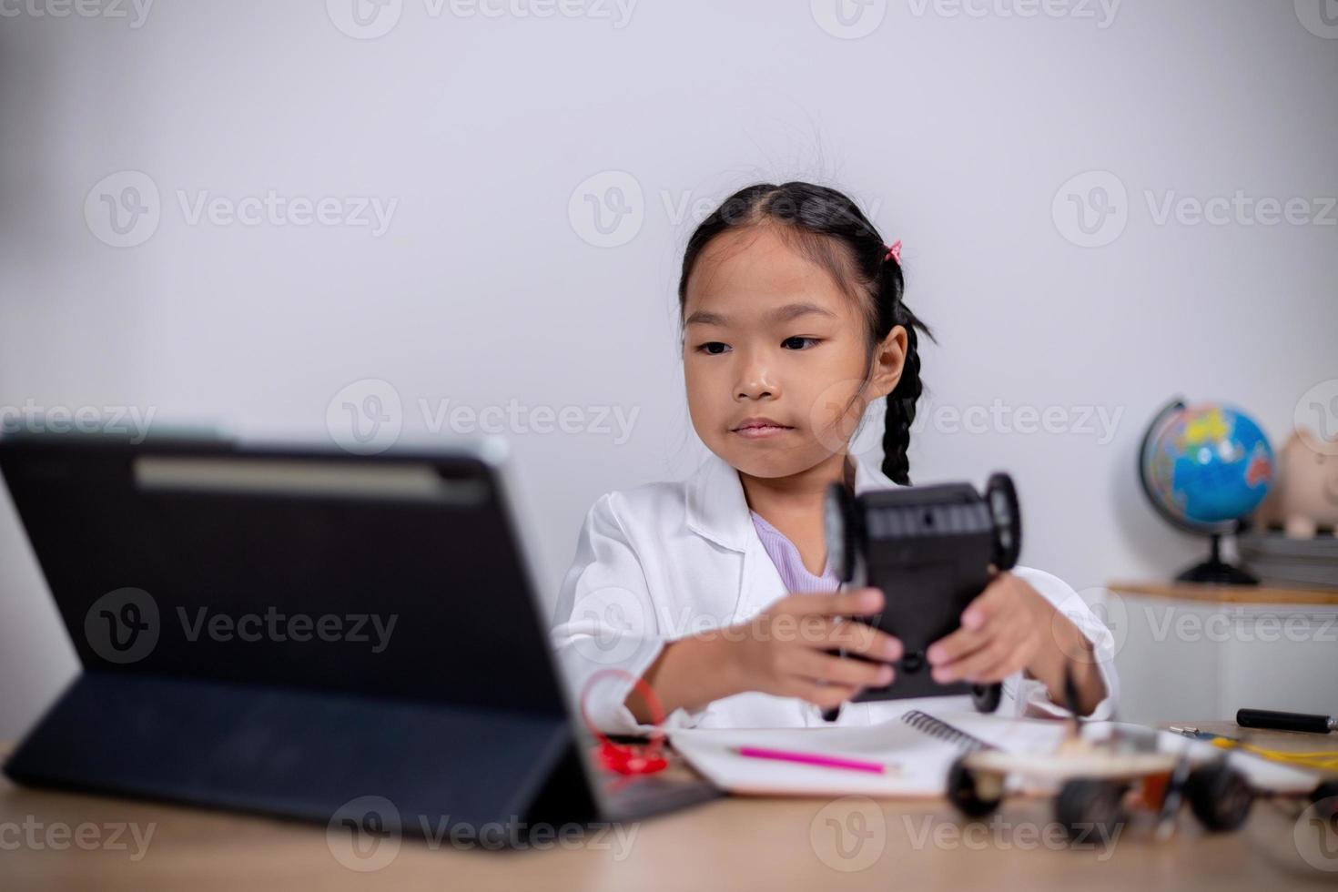 Asian students learn at home by coding robot cars and electronic board cables in STEM, STEAM, mathematics engineering science technology computer code in robotics for kids' concepts. photo
