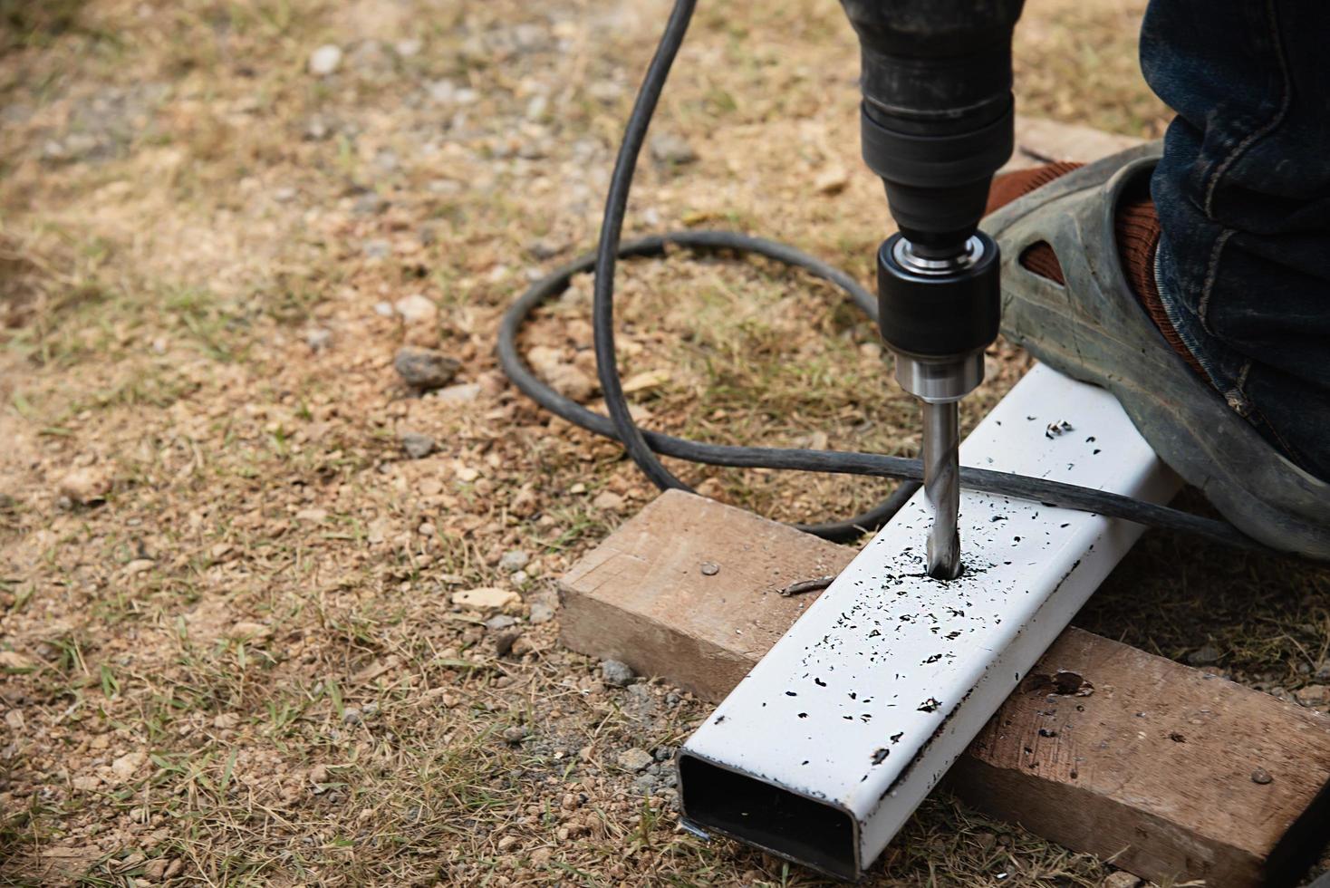 construction man is using hand drilling machine making steel