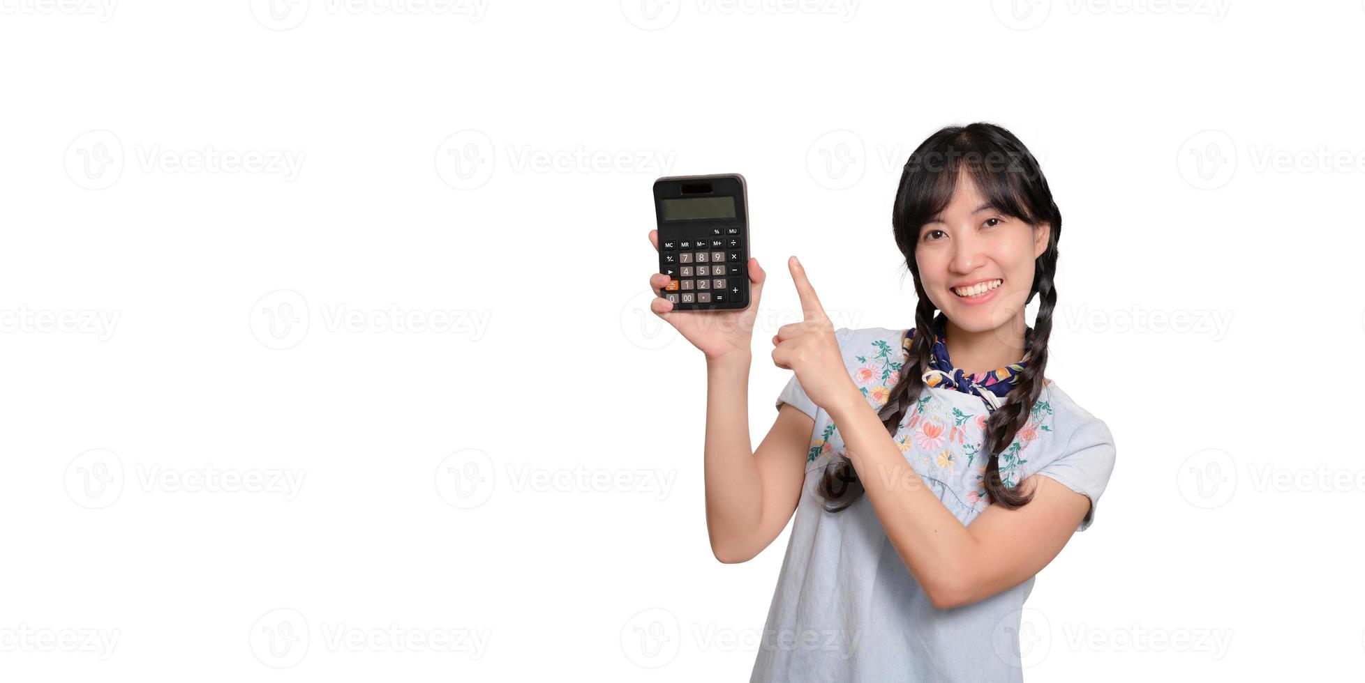 Portrait of beautiful young asian woman in denim dress holding calculator on white background. business shopping online concept. photo