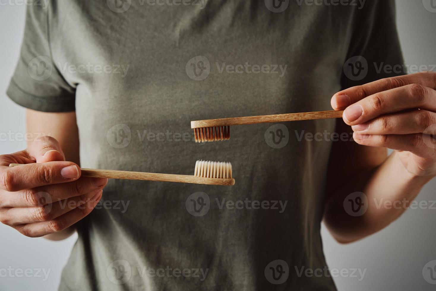 mujer sostiene cepillos de dientes de bambú, cierra foto